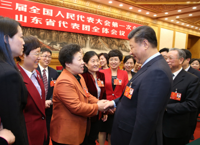On Women's Day, President Xi Jinping shakes hands with female deputies visiting Beijing from Shandong Province for the 13th National People's Congress (NPC). [Photo: Xinhua/Yao Dawei]
