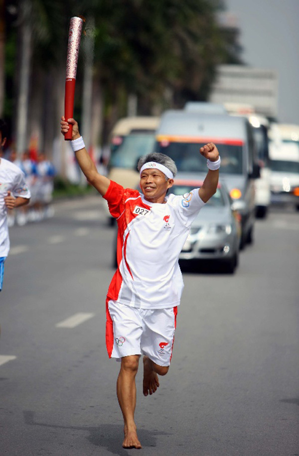 Barefoot marathon runner Wu Jiase runs with the Olympic torch in 2008 before the Olympic Games in Beijing. [Photo: thepaper.cn]