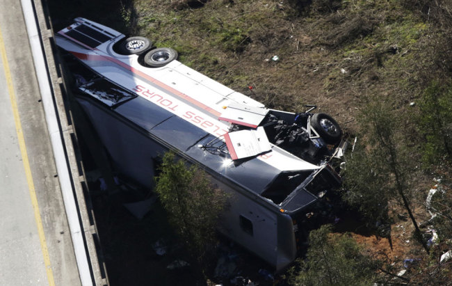 A charter bus sits in a ravine after a deadly crash on Tuesday, March 13, 2018, in Loxley, Ala. The bus carrying Texas high school band members home from Disney World plunged into the ravine before dawn Tuesday. [Photo: AP/Dan Anderson]