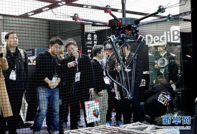 Visitors watch how a 3D printer carried by drone operates at the Shanghai New International Expo Center on March 1, 2018. [File photo: Xinhua]