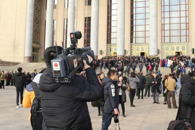 Journalists covering the opening session of the 13th National People's Congress (NPC) at work outside the Great Hall of the People in Beijing on March 5,2018, in Beijing. [Photo: China Plus]