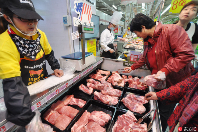 Customers shop for pork imported from U.S. at a supermarket in Zhengzhou city, central Chinas Henan province, 22 March 2014. [File Photo: IC]