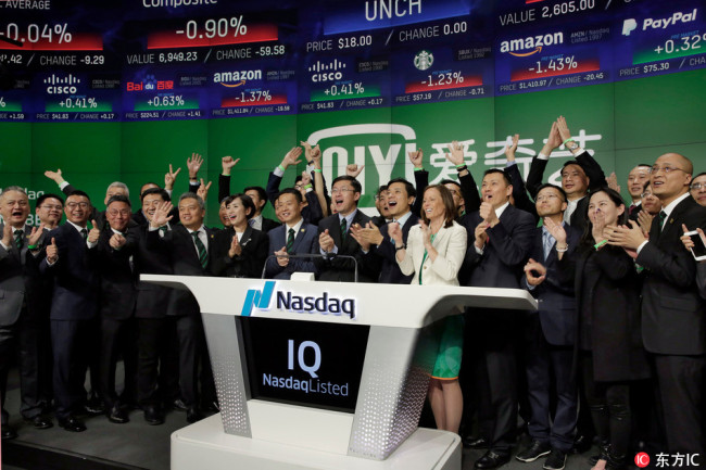 iQIYI Founder & CEO Yu Gong, center, and Robin Li, center right, co-founder of the search engine Baidu, ring the Nasdaq MarketSite opening bell, during iQIYI IPO listing ceremonies, in New York's Times Square, Thursday, March 29, 2018. [Photo: IC]