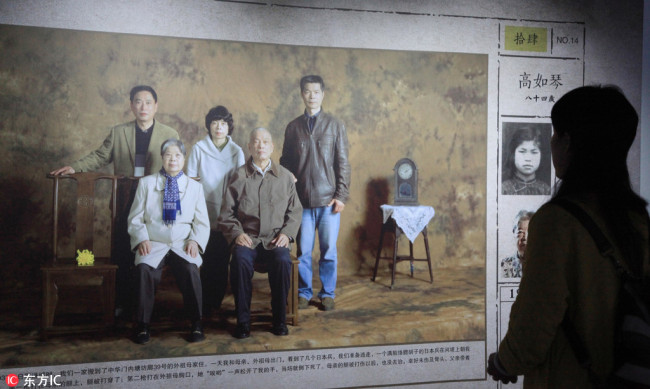 A man visits the exhibition of family photos of survivors of the Nanjing Massacre opened in Nanjing on April 3, 2018. [Photo: IC]