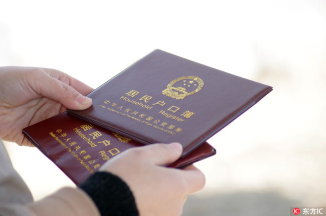 A local Chinese resident shows his household register, also known as hukou, in Ji'nan city, east China's Shandong province, February 5, 2018.[File Photo: IC]