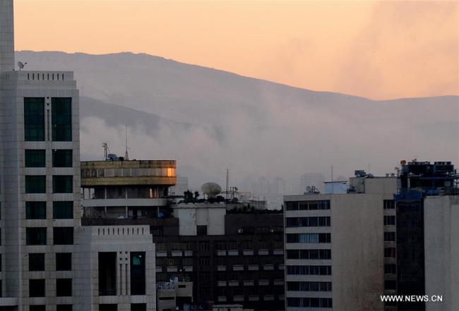 Smoke is seen from a distance in the Syrian capital Damascus on April 14, 2018. The U.S. started military actions against Damascus before daybreak Saturday as loud explosions were heard with "red dots" seen flying from earth to the sky, reported Syrian state TV and Xinhua reporters in Damascus. [Photo: Xinhua]