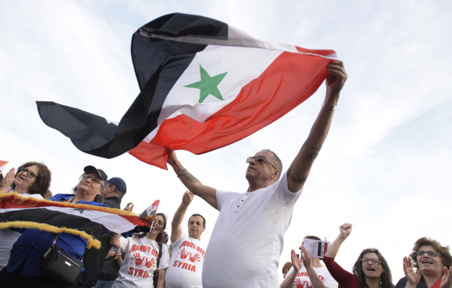 John Haddad, of Allentown, waves a Syrian flag as members of the Syrian community celebrate Syrian Independence Day during a ceremony at St. George Orthodox Church on Saturday, April 14, 2018, in Allentown, Pa. [Photo: AP/Matt Smith]