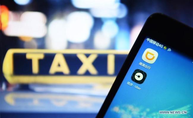 Photo taken on Aug. 1, 2016 shows Apps of Didi and Uber on a cellphone of a citizen in Hangzhou, capital of east China's Zhejiang Province. [File photo: Xinhua]