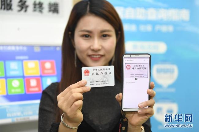 A resident shows her electronic ID card in Hangzhou, Zhejiang Province, on Tuesday, April 17, 2018. [Photo: Xinhua]