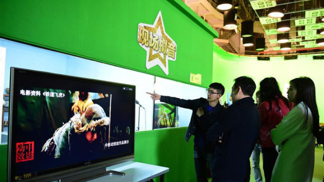 Visitors experience the virtual stage at the film carnival in Beijing on April 14, 2018. [Photo: Xinhua]