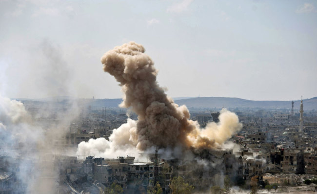 In this photo released by the Syrian official news agency SANA, smoke rises after Syrian government airstrikes and shelling hit in Hajar al-Aswad neighborhood held by Islamic State militants, southern Damascus, Syria, Sunday, April 22, 2018. Syrian state media says government forces are pounding districts of southern Damascus held by Islamic State militants with warplanes, helicopters and artillery in a bid to enforce an evacuation deal reached earlier in the week. [Photo: AP]