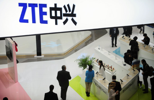 People gather at the ZTE booth at the Mobile World Congress, the world's largest mobile phone trade show in Barcelona, Spain, Wednesday, Feb. 26, 2014. The global wireless show that wraps up on Thursday has seen a push to get mobile devices cheap enough to reach emerging markets without sacrificing so much performance. While the affluent crave the latest iPhones or Android phones, most of the world can't afford the hundreds of dollars they cost. [Photo: AP]