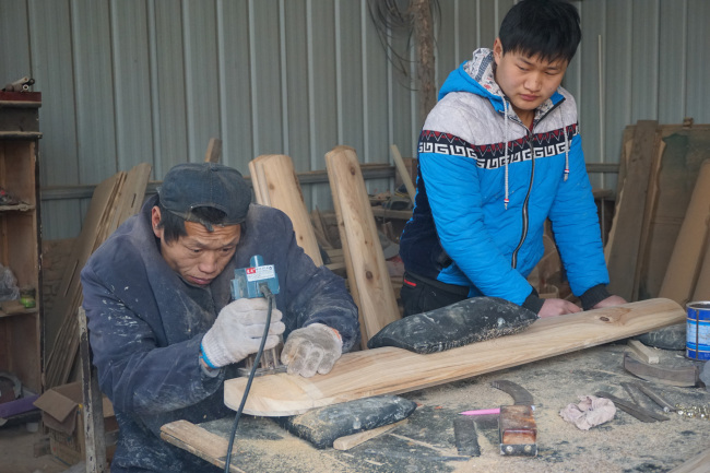 Workers from Xu Paihang’s shop were making zithers, a stringed musical instrument. [Photo: from China Plus]