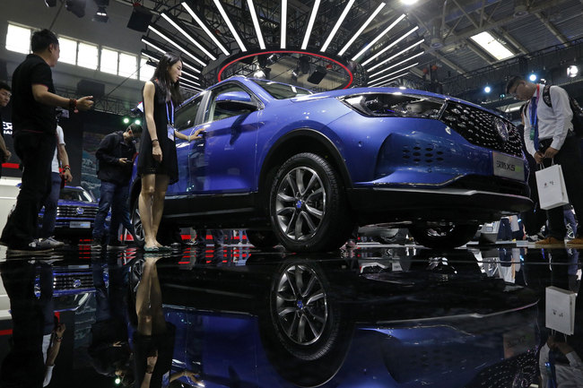 Journalists and visitors look at a Chinese car brand Hanteng X5 EV SUV on display at the China Auto China in Beijing, Thursday, April 26, 2018. Auto China 2018, the industry's biggest sales event this year, is overshadowed by mounting trade tensions between Beijing and U.S. President Donald Trump, who has threatened to hike tariffs on Chinese goods including automobiles in a dispute over technology policy.[Photo:AP]