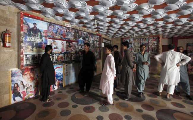 Pakistani cinema-goers look at photos displayed at a local cinema in Karachi, Pakistan, Sunday, Dec. 18, 2016.[Photo: AP/Fareed Khan]