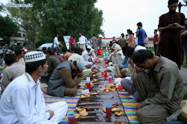 Pakistani Muslims wait to break their fast on the first day of the holy month of Ramadan in Islamabad, capital of Pakistan, on May 17, 2018. 