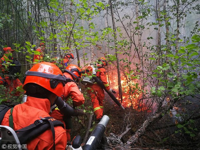 Firefighters work to extinguish the blaze at a forest in the Greater Hinggan Mountains, North China's Inner Mongolia autonomous region, June 3, 2018. [Photo/Xinhua]