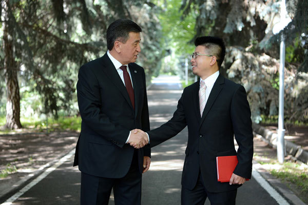 Kyrgyz President Sooronbai Jeenbekov (Left) shakes hands with a journalist from China Radio International. [Photo: China Plus]
