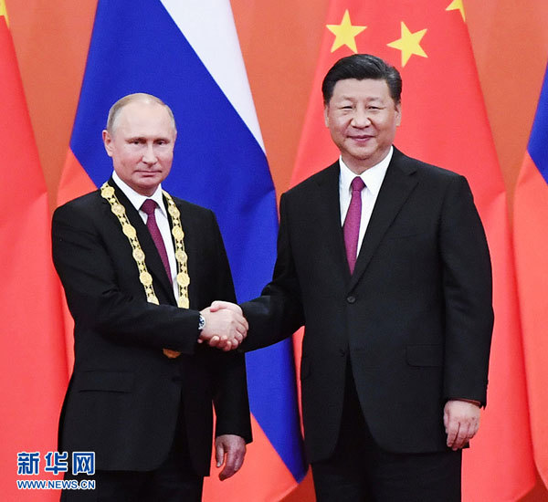 Chinese President Xi Jinping (Right) awards his Russian counterpart Vladimir Putin the first-ever Friendship Medal of the People's Republic of China at the Great Hall of the People in Beijing, capital of China, June 8, 2018. [Photo: Xinhua/Yao Dawei]