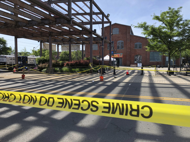 Police crime-scene tape keeps people away from the brick Roebling Wire Works building, background, in Trenton, N.J., hours after a shooting broke out there at an all-night art festival early Sunday, June 17, 2018, sending people stampeding from the scene and leaving one suspect dead and at least 20 people injured. [Photo: AP/Mike Catalini]