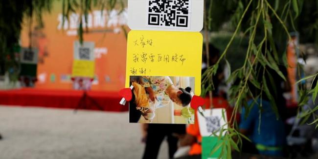 Charity cards are hung on tree branches and alongside a mountain road. People can scan the QR codes and make donations to help children who are in need. [Photo: China Plus/Xu Yawen]