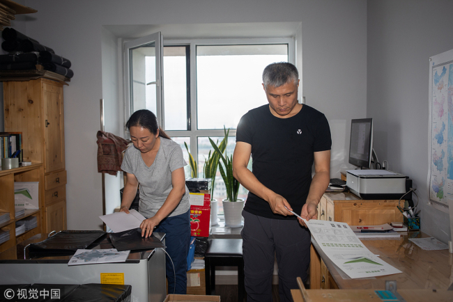 Liu Dong and his wife are busy in packing paper planes. [Photo/VCG]