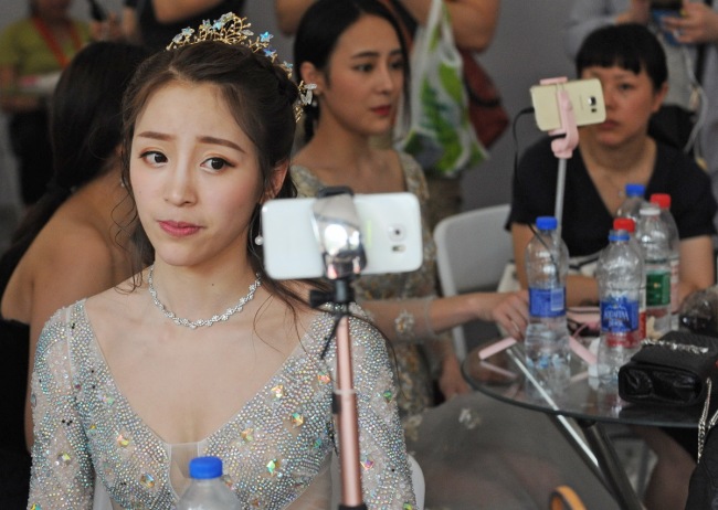 An online celebrity reacts for her followers via a livestreaming app in Wuhan, capital of Hubei province. [File Photo: China Daily]