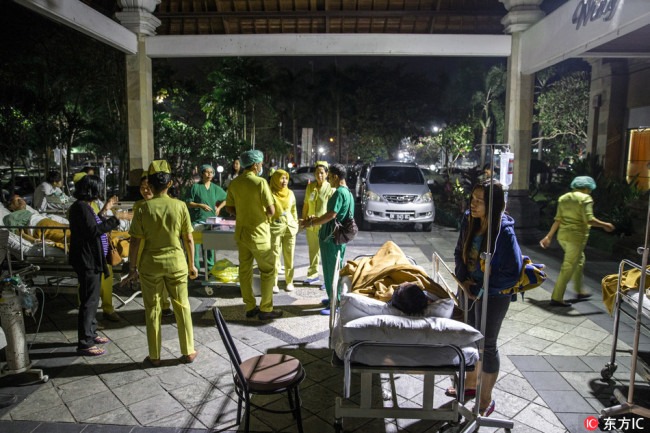A hospital patient is moved outside of the hospital building after an earthquake was felt in Denpasar, Bali, Indonesia, 05 August 2018. [Photo: IC]