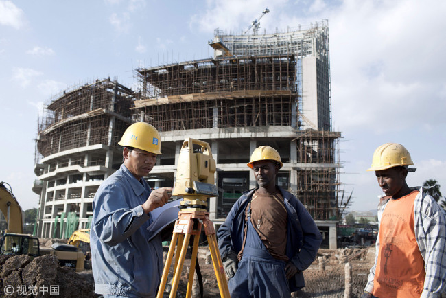A Chinese construction worker with Ethiopian workers at the new African Union Buildings in Addis Ababa, Ethiopia on October 17, 2010. The building is built for free. [File photo: eyevine/Per-Anders Pettersson]
