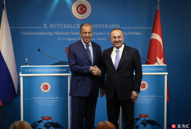Minister of Foreign Affairs of Turkey, Mevlut Cavusoglu (R) and Russian Foreign Minister Sergey Lavrov (L) shake hands during a joint press conference held within the 10th Ambassadors' Conference in Ankara, Turkey on August 14, 2018. [Photo：IC]