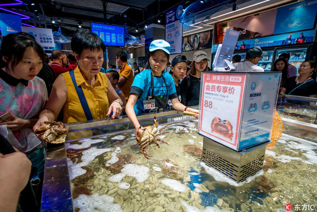 Customers shop at a store of O2O fresh produce retailer Hemaxiansheng, also known as Hema Fresh Store, of Chinese e-commerce giant Alibaba Group in Guangzhou city, south China's Guangdong province, 29 July 2018. [Photo:IC]