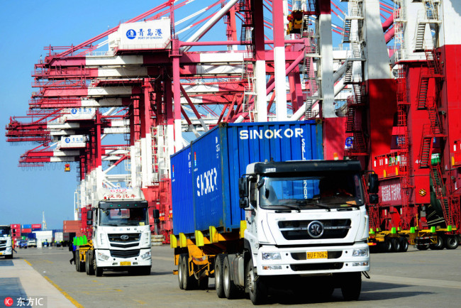 Trucks transport containers to be shipped abroad on a quay at the Port of Qingdao in Qingdao City, Shandong Province, on April 13, 2018. [Photo: IC]