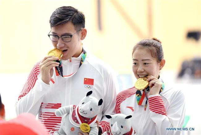 Wu Jiayu (L)/Ji Xiaojing of China pose for pictures after winning the 10m Air Pistol Mixed Team gold medal at the 18th Asian Games in Palembang, Indonesia Aug. 19, 2018. [Photo: Xinhua/Cheng Min]