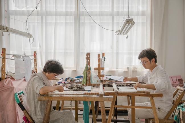 Zhang Xue and his mother work at his workshop in Suzhou, Jiangsu province, on Aug 2, 2018. [Photo/VCG]