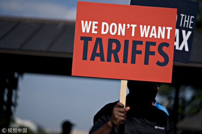 An autoworker holds a sign that reads "We Don't Want Tariffs" during a news conference on Capitol Hill in Washington, DC, US, on July 19, 2018. [Photo: VCG]
