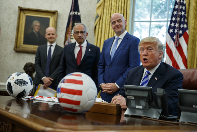 United States Soccer Federation president Carlos Cordeiro, second from left, and FIFA president Gianni Infantino, third from left, listen as President Donald Trump speaks during a meeting in the Oval Office of the White House, Tuesday, Aug. 28, 2018, in Washington. [Photo: AP/Evan Vucci]