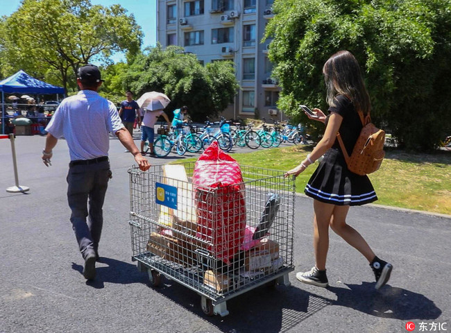 A student uses a trolley to carry her parcels back to the dormitory during the first week of the new semester at Jiangnan University in Wuxi City, Jiangsu Province on August 29, 2018. [Photo: IC]