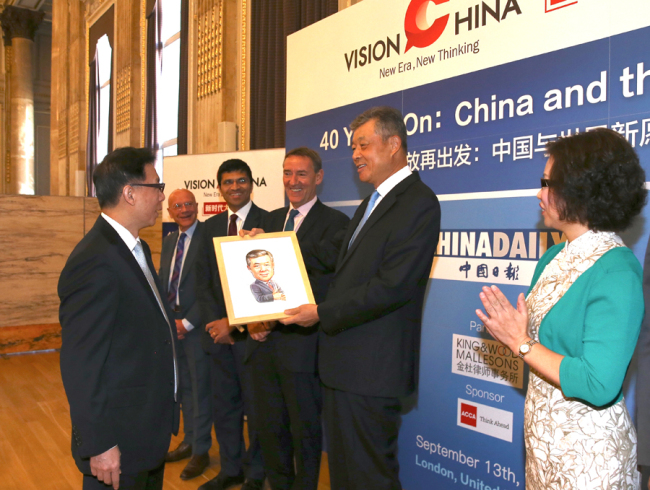 Editor-in-Chief of China Daily Zhou Shuchun (L1) gives gifts to guest speakers at China Daily's Vision China event in London, Sept 13, 2018. [Photo: chinadaily.com.cn]