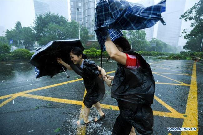 Pedestrians walk in the wind at Nanshan District in Shenzhen, south China's Guangdong Province, Sept. 16, 2018. According to China's National Meteorological Center, Mangkhut is expected to land in Guangdong between Sunday afternoon and evening. [Photo: Xinhua]