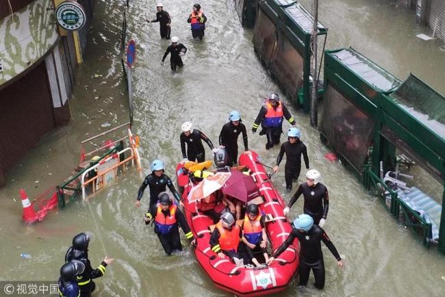Rescue workers help residents evacuate from a flooded community in Hong Kong, September 16, 2018. [Photo: VCG]