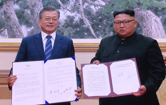 South Korean President Moon Jae-in (L) and top leader of the Democratic People's Republic of Korea (DPRK) Kim Jong Un show the agreement they signed after their third summit meeting in the DPRK's capital Pyongyang on Wednesday, September 19, 2018. [Photo: China Plus]