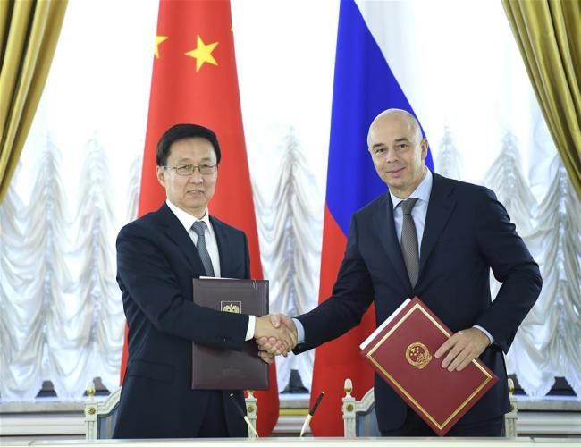 Chinese Vice Premier Han Zheng (L), also a member of the Standing Committee of the Political Bureau of the Communist Party of China (CPC) Central Committee, and Russian First Deputy Prime Minister Anton Siluanov sign the summary of minutes after the fifth meeting of the China-Russia Investment Cooperation Committee in Moscow, Russia, Sept. 18, 2018. Han met with Siluanov on Tuesday and co-chaired the meeting with him. [Photo: Xinhua]