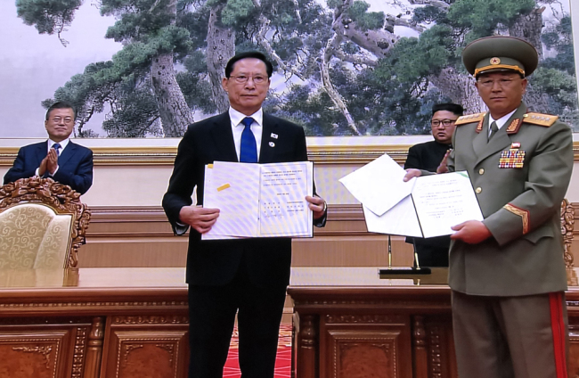 Defense chiefs of South Korea and the Democratic People's Republic of Korea (DPRK) show the agreement on military affairs they signed at the Baekhwawon State Guest House in Pyongyang, with the leaders of the two Koreas standing behind, on Wednesday, September 19, 2018. [Photo: China Plus]