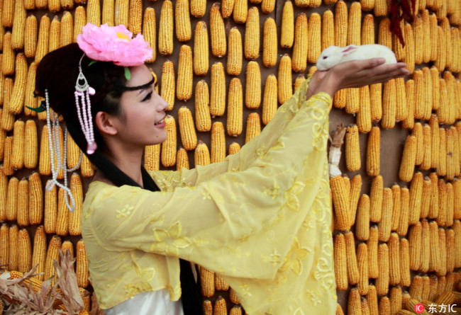 A young lady dressed up as Chang'e, the Chinese moon goddess, holds a rabbit dubbed "Yutu" on her palm in order to attract customers. Chang'e is a mythological figure known among Chinese for her beauty and kindness.[Photo:IC]