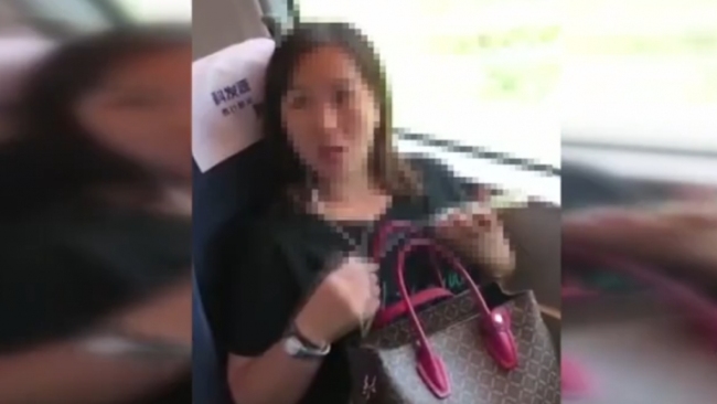 A woman refuses to leave a window seat that belongs to another passenger on a train from Yongzhou to Shenzhen in this still image obtained from a social media video, September 19, 2018. [Screenshot: China Plus]