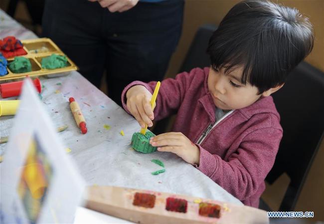 A child makes mooncake with plasticine during the Mid-Autumn Moon Family Festival event held at the Museum of Chinese in America (MOCA) in New York, the United States, Sept. 22, 2018. [Photo: Xinhua] 