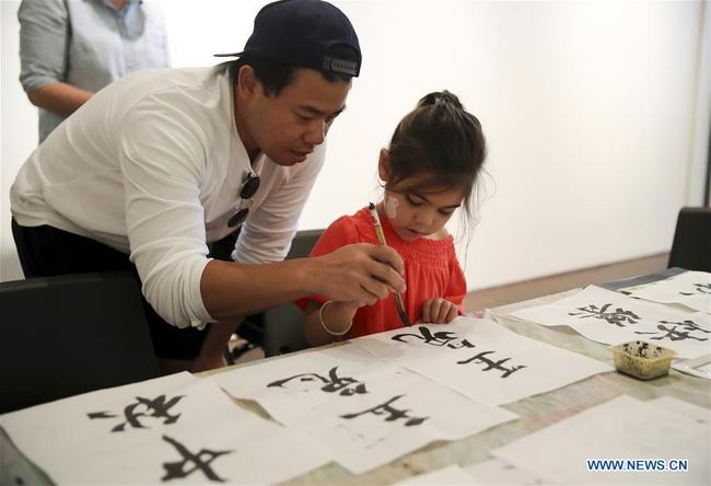 A child practices Chinese calligraphy during the Mid-Autumn Moon Family Festival event held at the Museum of Chinese in America in New York, the United States, Sept. 22, 2018. [Photo: Xinhua] 