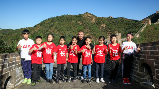 British football star David Beckham and Chinese children at the Great Wall on Sept. 23.[Photo: people.com.cn]