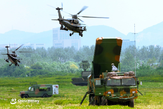 Multi-type attack helicopters attached to an army aviation brigade under the PLA 72nd Group Army hover over vehicle-mounted air defense radar systems, air defense missile systems and communications systems of an air defense brigade during a joint training exercise on August 18, 2018. [Photo: chinamil.com.cn/Zhang Huanpeng]