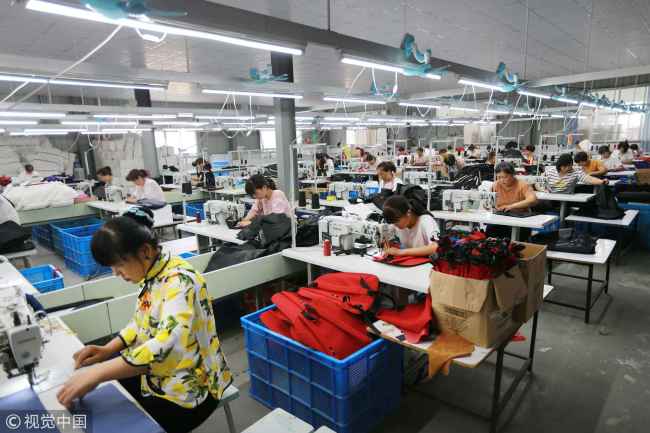 Workers are making export bags at a luggage production workshop in Huaibei City, Anhui Province on July 6, 2018. [Photo: VCG]